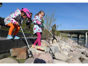 Five year-olds Serena Wu, left and Noa Wiarda help out looking for garbage along the Bow River in the East Village on Sunday, May 1, 2016.  The two were among hundreds of volunteers who participated in the annual Pathway and River Cleanup in the city.