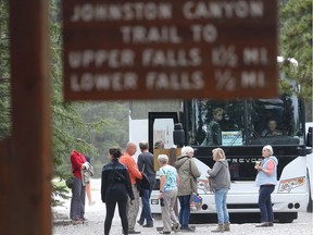 A tour bus loads up at the base of the Johnston Canyon trail in Banff National Park  in May 2016.
