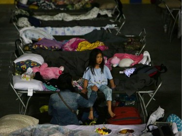 A young girl sits on a cot at a makeshift evacuee center in Lac la Biche on May 5.