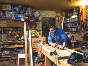 Local musician and woodworker Brendan Tate works in the workshop where he built the portable shelf for CJSW and the Calgary Public Library's Calgary Local Music Library.