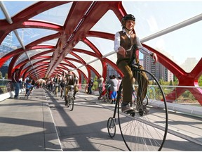 Participants in Calgary's annual Tweed Ride cycle over the Peace Bridge in downtown Calgary in 2015.