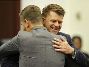 Wildrose leader Brian Jean (R) embraces Derek Fildebrandt during a swearing-in ceremony in the house of the Alberta Legislature June 1, 2015.