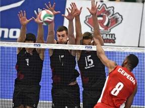 From left, Canada's Tyler Sanders (1), Graham Vigrass (17) and Frederic Winters (15) go up for a block on Cuba Rolando Cepeda Abreu (8) in the finals match of the NORCECA Men's Continental Olympic volleyball qualification tournament at Saville Centre in Edmonton on January 11, 2016.