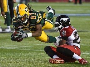Edmonton Eskimos Derel Walker (87) goes for extra yardage after making a catch against Calgary Stampeders Keon Raymond (25) during the CFL Western Final at Commonwealth Stadium in Edmonton, November 22, 2015.