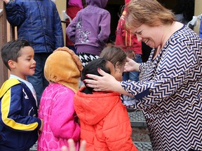 St. John XXIII school principal Melina Akins talks to students during a morning recess at the Falconridge kindergarten to Grade 9 school.