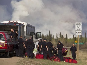 Fire Rescue crews unload in preparation to battle a wildfire in Fort McMurray, Alta., on Thursday, May 5, 2016. An ever-changing, volatile situation is fraying the nerves of residents and officials alike as a massive wildfire continues to bear down on the Fort McMurray area of northern Alberta.