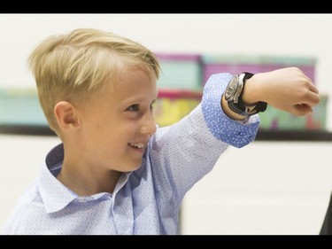 Britton Walker, 8, shows off his James Bond watch during an assembly at Royal Oak School in Calgary, Alta., on Monday, May 16, 2016. Walker, a huge James Bond fan who has appeared on Ellen and who through whom he met Bond actor Daniel Craig, was given a large portion of collector Wayne Rooke's extensive trove of James Bond memorabilia; his school paid forward the generosity by raising money for Fort McMurray fire victims. Lyle Aspinall/Postmedia Network