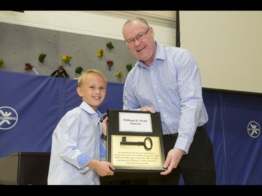 Britton Walker, 8, presents a key to Doug Smith, principal of the new William D. Pratt School, at Walker's school next door, Royal Oak School, in Calgary, Alta., on Monday, May 16, 2016. Walker, a huge James Bond fan who has appeared on Ellen and who through whom he met Bond actor Daniel Craig, was given a large portion of collector Wayne Rooke's extensive trove of James Bond memorabilia; his school paid forward the generosity by making this gift for the neighbouring school and by raising money for Fort McMurray fire victims. Lyle Aspinall/Postmedia Network