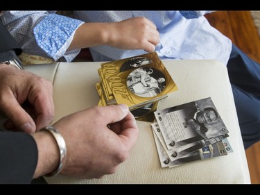 Britton Walker, 8, looks at James Bond trading cards with collector Wayne Rooke in Walker's home in Calgary, Alta., on Monday, May 16, 2016. Walker, a huge James Bond fan who has appeared on Ellen and who through whom he met Bond actor Daniel Craig, was given a large portion of collector Wayne Rooke's extensive trove of James Bond memorabilia; his school paid forward the generosity by raising money for Fort McMurray fire victims. Lyle Aspinall/Postmedia Network