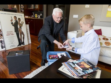 Britton Walker, 8, gratefully begins receiving a trove of James Bond memorabilia from collector Wayne Rooke at Walker's home in Calgary, Alta., on Monday, May 16, 2016. Walker, a huge James Bond fan who has appeared on Ellen and who through whom he met Bond actor Daniel Craig, was given a large portion of collector Wayne Rooke's extensive trove of James Bond memorabilia; his school paid forward the generosity by raising money for Fort McMurray fire victims. Lyle Aspinall/Postmedia Network