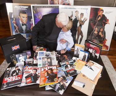 Britton Walker, 8, and collector Wayne Rooke pose for a photo with a bevy of James Bond memorabilia inside Walker's home in Calgary, Alta., on Monday, May 16, 2016. Walker, a huge James Bond fan who has appeared on Ellen and who through whom he met Bond actor Daniel Craig, was given a large portion of collector Wayne Rooke's extensive trove of James Bond memorabilia; his school paid forward the generosity by raising money for Fort McMurray fire victims. Lyle Aspinall/Postmedia Network