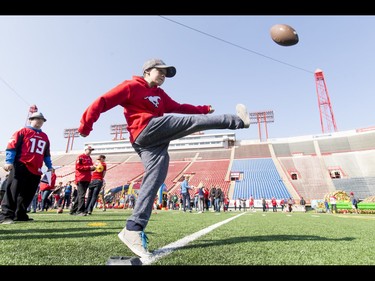 Austin Mclean, 12, tries for a field goal as his buddy Daylan Watson (L), 12, looks on during the Calgary Stampeders Fanfest at McMahon Stadium in Calgary, Alta., on Saturday, May 14, 2016. The event featured player autographs, a pancake breakfasts and family games. Lyle Aspinall/Postmedia Network