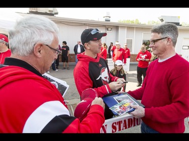 New head coach Dave Dickenson signs autographs for fans Greg Ingram (L) and Phil Harding during the Calgary Stampeders Fanfest at McMahon Stadium in Calgary, Alta., on Saturday, May 14, 2016. The event featured player autographs, a pancake breakfasts and family games. Lyle Aspinall/Postmedia Network