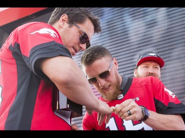 Quarterback Bo Levi Mitchell eyes the President's Ring on the finger of teammate Rob Cote during the Calgary Stampeders Fanfest at McMahon Stadium in Calgary, Alta., on Saturday, May 14, 2016. The event featured player autographs, a pancake breakfasts and family games. Lyle Aspinall/Postmedia Network