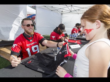 Quarterback Bo Levi Mitchell signs an autograph for fan Savannah Whelan during the Calgary Stampeders Fanfest at McMahon Stadium in Calgary, Alta., on Saturday, May 14, 2016. The event featured player autographs, a pancake breakfasts and family games. Lyle Aspinall/Postmedia Network