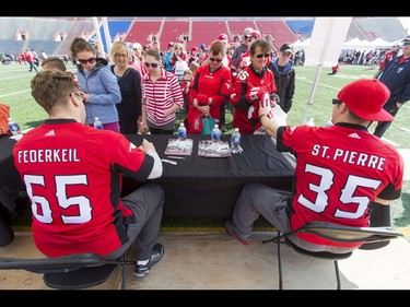 Daniel Federkeil and Tim St. Pierre sign autographs during the Calgary Stampeders Fanfest at McMahon Stadium in Calgary, Alta., on Saturday, May 14, 2016. The event featured player autographs, a pancake breakfasts and family games. Lyle Aspinall/Postmedia Network