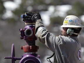 In this March 29, 2013 photo, a worker switches well heads during a short pause in the water pumping phase, at the site of a natural gas hydraulic fracturing and extraction operation run by Encana Oil & Gas (USA) Inc., outside Rifle, Colo. The Colorado Supreme Court has struck down attempts by two cities to ban or delay fracking.