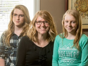 Kristy Thackeray and her twin daughters Shaylynn (R) and McKayla, 14, take time for a photo inside their home in Chestermere, Alta., on Saturday, May 14, 2016. Kristy is celebrating 20 years since a heart transplant in her teens.