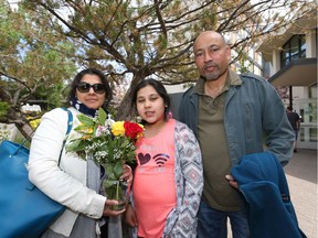 (L- R) Amber Arshad,  daughter Hadrah Arshad, 10 yrs, and dad Arshad Viqar pose after flowers were given to mothers at a lunch provided for Fort McMurray evacuees at the Univerity of Calgary on Sunday May 8, 2016. The university has opened up housing and  virtually all the other facilities to families who have been evactated from Fort McMurray due to the wildfires. Jim Wells//Postmedia
