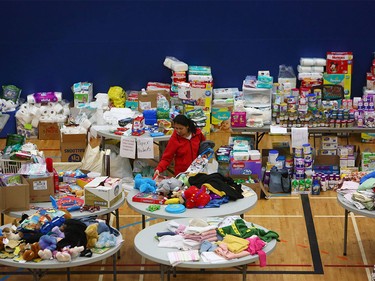 A woman picks through donated clothing and goods at a makeshift  evacuee center in Lac la Biche, Alberta on May 5, 2016, after fleeing forest fires north of Fort McMurray.