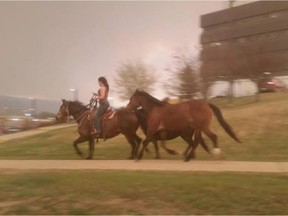 Local Input~ A woman seen galloping on horseback through downtown Fort McMurray Tuesday, fleeing a wildfire that's caused a mandatory evacuation. (Submitted by Julie Lodge)