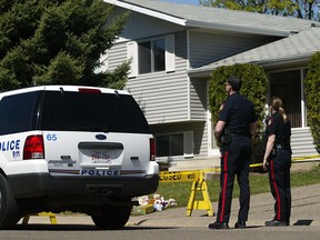 Police outside the house in 2006 where "J.R." helped her 23-year-old boyfriend, Jeremy Allan Steinke, murder her Medicine Hat parents and eight year-old brother.