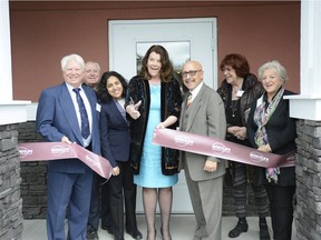 Alberta Minister of Seniors and Housing Lori Sigurdson, centre, cuts the ribbon at the opening of Kingsland Terrace in Calgary on April 29, 2016.