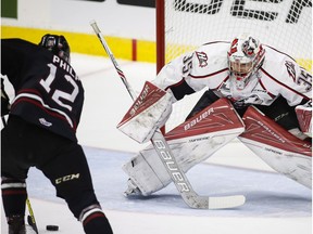 Rouyn-Noranda Huskies goalie Chase Marchand, right, is pressured by Red Deer Rebels' Luke Philp during first period CHL Memorial Cup semi-final hockey action in Red Deer, Friday, May 27, 2016.THE CANADIAN PRESS/Jeff McIntosh ORG XMIT: JMC106