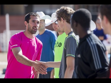 Thomas Toth shakes hands with other runners while accepting his award for winning the half-marathon portion of the Calgary Marathon at the Stampede Grounds in Calgary, Alta., on Sunday, May 29, 2016. There were 5k, 10k, 21.1k, 42.2k and 50k distances in the race, including the half-marathon national championships. Lyle Aspinall/Postmedia Network