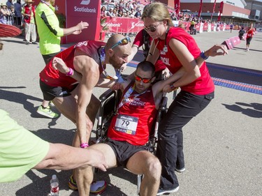 Calum Neff collapses into a wheelchair after finishing second in the 50-km ultra portion of the Calgary Marathon at the Stampede Grounds in Calgary, Alta., on Sunday, May 29, 2016. There were 5k, 10k, 21.1k, 42.2k and 50k distances in the race, including the half-marathon national championships. Lyle Aspinall/Postmedia Network