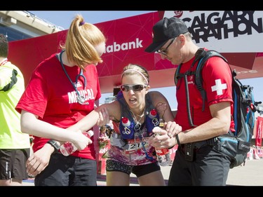 Lori Vickerman is helped by medical workers after finishing the Calgary Marathon at the Stampede Grounds in Calgary, Alta., on Sunday, May 29, 2016. There were 5k, 10k, 21.1k, 42.2k and 50k distances in the race, including the half-marathon national championships. Lyle Aspinall/Postmedia Network