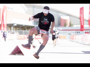 Ben Rendle strikes a skeleton kick while holding a beer at the end of the Calgary Marathon at the Stampede Grounds in Calgary, Alta., on Sunday, May 29, 2016. There were 5k, 10k, 21.1k, 42.2k and 50k distances in the race, including the half-marathon national championships. Lyle Aspinall/Postmedia Network