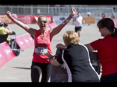 Jessica Mueller beats volunteers to the finish line to win the women's 50-km ultra portion of the Calgary Marathon at the Stampede Grounds in Calgary, Alta., on Sunday, May 29, 2016. There were 5k, 10k, 21.1k, 42.2k and 50k distances in the race, including the half-marathon national championships. Lyle Aspinall/Postmedia Network