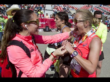 Jessica Mueller (R) celebrates with race executive director Kirsten-Ellen Fleming after winning the women's 50-km ultra portion of the Calgary Marathon at the Stampede Grounds in Calgary, Alta., on Sunday, May 29, 2016. There were 5k, 10k, 21.1k, 42.2k and 50k distances in the race, including the half-marathon national championships. Lyle Aspinall/Postmedia Network