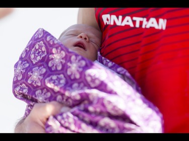 Ultra-marathon winner Jacob Puzey holds his two-week-old daughter Ashima after completing the Calgary Marathon at the Stampede Grounds in Calgary, Alta., on Sunday, May 29, 2016. There were 5k, 10k, 21.1k, 42.2k and 50k distances in the race, including the half-marathon national championships. Lyle Aspinall/Postmedia Network