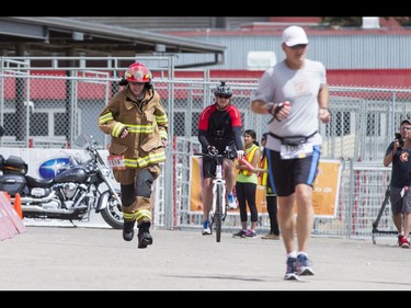 Olds firefighter Noel Darcy runs to the finish line while completing the Calgary Marathon at the Stampede Grounds in Calgary, Alta., on Sunday, May 29, 2016. Darcy wore full firefighting gear for the entire 42.2-km distance, and finished in a time of 5:25:03. There were 5k, 10k, 21.1k, 42.2k and 50k distances in the race, including the half-marathon national championships. Lyle Aspinall/Postmedia Network