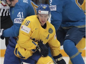 Sweden's Mikael Backlund, center, struggles for a puck with Kazakhstan's Dustin Boyd, left, and Roman Savchenko during the Ice Hockey World Championships Group A match between Sweden and Kazakhstan, in Moscow, Russia, on Wednesday, May 11, 2016.