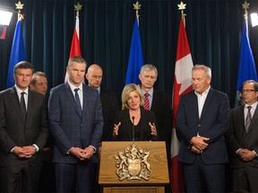 Premier Rachel Notley speaks to the media along with Suncor President and CEO Steve Williams, right, and President and CEO Canadian Association of Petroleum Producers Tim McMillan, left, at the Alberta Legislature in Edmonton, Alberta, on Tuesday, May 10, 2016. They met to discuss recovery strategies, including prioritizing restarting industrial activities, moving forward in Fort McMurray after the devastating wildfires.