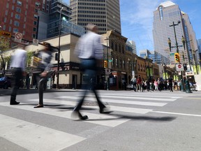 Pedestrians walk in downtown Calgary during lunch hour on Monday, May 2, 2016. .