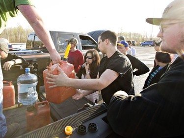 People gather for gas that is being handed out at a rest stop near Fort McMurray on Wednesday, May 4, 2016.