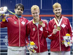 Canadian men's squash team, from left to right, Shawn Delierre, Andrew Schnell, and Graeme Schnell pose with their gold medal in men's team squash at the 2015 Pan Am Games in Toronto on Friday, July 17, 2015.