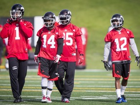 (L-R) Lemar Durant, Roy Finch, Lache Seastrunk and Reggie Whatley walk during the Calgary Stampeders training camp in Calgary, Alta., on Monday, May 30, 2016. The regular season begins on June 25, when the Stamps head to B.C. Lyle Aspinall/Postmedia Network