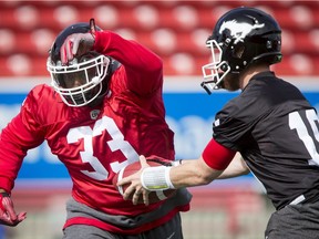 Jerome Messam and quarterback Bo Levi Mitchell run through a drill during the Calgary Stampeders training camp in Calgary, Alta., on Monday, May 30, 2016. The regular season begins on June 25, when the Stamps head to B.C. Lyle Aspinall/Postmedia Network