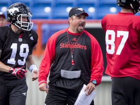Offensive line coach Pat DelMonaco barks orders between quarterback Bo Levi Mitchell and Simon Charbonneau  during the Calgary Stampeders training camp at McMahon Stadium in Calgary, Alta., on Tuesday, May 31, 2016. The regular season begins on June 25, when the Stamps head to B.C. Lyle Aspinall/Postmedia Network