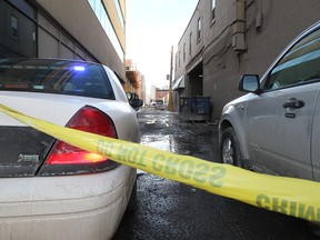 Police investigate the scene of the fatal stabbing of Lukas Strasser-Hird in an alley in the 200 block between 10th and 11th avenue S.W.