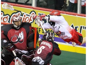 The Calgary Roughnecks' Curtis Dickson goes airborne to  to try and score on Colorado Mammoth goalie Alex Buque during National Lacrosse League action at the Scotiabank Saddledome on Saturday March 19, 2016.  (Gavin Young/Postmedia) (For Sports section story by Scott Mitchell) Trax#