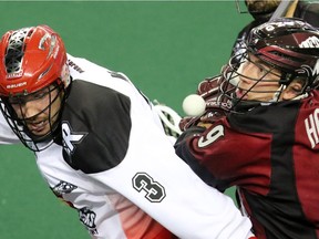 The Calgary Roughnecks' Dan MacRae, left and Colorado Mammoth Cameron Holding collide along with the ball during National Lacrosse League action at the Scotiabank Saddledome on Saturday March 19, 2016.  (Gavin Young/Postmedia) (For Sports section story by Scott Mitchell) Trax#