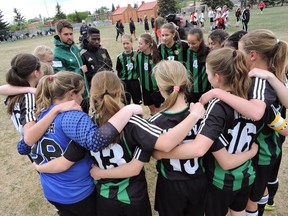 The Foothills '02 Girls celebrate with coach Jay Wheeldon and assistant Elijah Adekugbe after winning a tournament May 8 that sends them, all-expenses-paid, to the Gothia Cup in July.