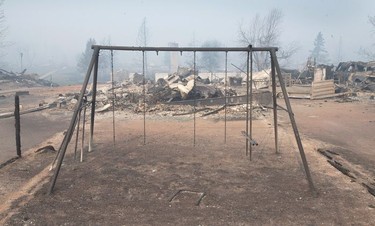 A swing set with the swings burned away sits in a residential neighborhood destroyed by a wildfire  in Fort McMurray.