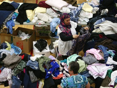 A woman picks through donated clothing and goods at a makeshift evacuee centre in Lac la Biche, Alberta on May 5, 2016, after fleeing forest fires north of Fort McMurray. Raging wildfires pressed in on the Canadian oil city of Fort McMurray Thursday after more than 80,000 people were forced to flee, abandoning fire-gutted neighborhoods in a chaotic evacuation.